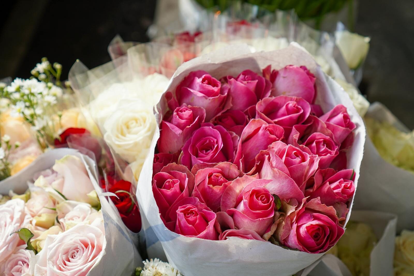 Beautiful bouquet of pink roses surrounded by various floral arrangements, perfect for festive occasions.