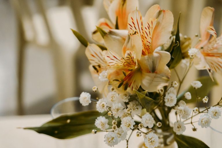Beautiful bouquet featuring exotic lilies and delicate white flowers in a neutral setting.